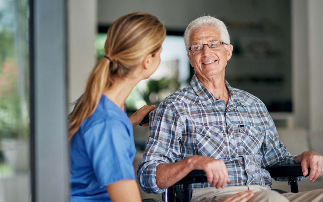 Senior receiving supportive care at home from professional caregivers and healthcare providers.